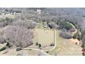 Picturesque aerial view showcasing a private lake with surrounding trees, well maintained grassy areas and home at 4229 Motocross Trl, Edgemoor, SC 29712