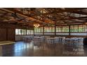 Bright event space with exposed rafters, chandeliers, and table seating at 4229 Motocross Trl, Edgemoor, SC 29712