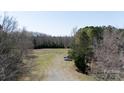 Expansive lot with a mix of cleared area, trees, and driveway access to the open land for potential development at 4229 Motocross Trl, Edgemoor, SC 29712
