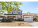 Charming two-story home with a brick facade, well-manicured landscaping, and an attached two-car garage at 5827 Eleanor Rigby Rd, Charlotte, NC 28278