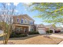 Well-maintained two-story home featuring a brick facade, lush landscaping, and a two-car attached garage at 5827 Eleanor Rigby Rd, Charlotte, NC 28278
