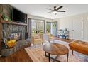 Cozy living room with a stone fireplace, comfortable seating, and plenty of natural light at 7656 Eastbourne Rd, Charlotte, NC 28227