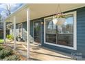 Inviting covered porch with hanging flower baskets, offering a cozy entrance to the home at 7656 Eastbourne Rd, Charlotte, NC 28227