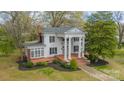 Elegant white home with grand columns, brick accents, and a spacious front yard with mature trees at 8425 E Franklin St, Mount Pleasant, NC 28124