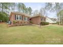 A charming brick home boasting meticulously maintained landscaping and a lush green lawn at 8801 Oldenburg Dr, Mount Pleasant, NC 28124