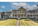 Charming yellow home with a red front door and a spacious front porch, nestled in a picturesque neighborhood at 9703 Cotton Stand Rd, Charlotte, NC 28277