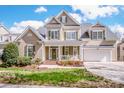 Beautiful two-story home with front porch, green shutters, and an attached two-car garage at 1027 Brookline Dr, Huntersville, NC 28078