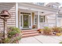 Covered front porch with brick steps, white columns, and a stained-glass front door at 1027 Brookline Dr, Huntersville, NC 28078