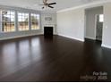 Open living room with fireplace, large windows, dark hardwood floors, and lots of natural light at 111 Canada Dr, Statesville, NC 28677