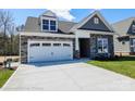 Charming home with stone accents, white garage door and a well-manicured lawn at 2011 Mantle Ridge Dr # 193, Wesley Chapel, NC 28079