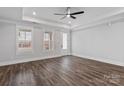 Bright main bedroom featuring wood floors, a tray ceiling, and a ceiling fan at 2063 Fordhill St, Rock Hill, SC 29732