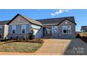 Charming single-Gathering home with stone accents, a two-car garage and manicured lawn at 2078 Fordhill St, Rock Hill, SC 29732