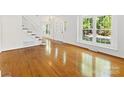 Sun-filled living room featuring gleaming hardwood floors and large windows at 5114 Glenbrier Dr, Charlotte, NC 28212