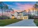 Stunning two-story home with a long driveway and well-manicured lawn at twilight at 6398 Chimney Bluff Rd, Lancaster, SC 29720