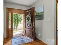 Inviting front door with decorative wreath, complemented by a patterned rug and sidelight window at 7146 Sifford Rd, Stanley, NC 28164