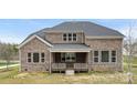 Rear view of a brick house featuring a covered back porch and well-maintained lawn at 2017 Belle Grove Dr, Waxhaw, NC 28173