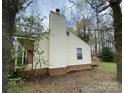 Home exterior featuring neutral siding, a brick foundation, and a chimney at 4825 Banfshire Rd # 28, Charlotte, NC 28215