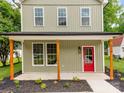 Inviting front porch featuring natural wood supports and a red door, framed by manicured landscaping at 570 Key West Ave, Kannapolis, NC 28081