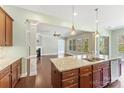 Bright kitchen showcasing a center island, pendant lighting, granite counters, stainless sink and hardwood floors at 11037 Thornbeck Ln, Midland, NC 28107