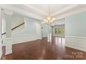 Open-concept living area with hardwood floors and an elegant staircase with classic white railings at 11037 Thornbeck Ln, Midland, NC 28107