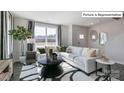 Bright living room with a comfortable white sectional, stylish decor, and a large window at 2048 Harlequin Dr, Indian Trail, NC 28079