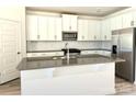 Bright kitchen featuring white cabinets, stainless steel appliances, a spacious island, and stylish backsplash at 313 Knotty Wood Dr # 79, Monroe, NC 28110