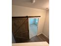 Bedroom entrance featuring sliding barn door leading to carpeted bedroom at 8232 Waxhaw Hwy, Waxhaw, NC 29173