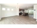 Open-concept living space with wood-look floors connecting the living room, kitchen and breakfast nook at 8232 Waxhaw Hwy, Waxhaw, NC 29173