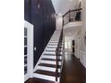 An elegantly designed staircase with dark wood floors and white risers and dark trim leading to upper level at 10928 Jardin Way, Charlotte, NC 28215