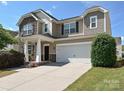 Attractive two-story home with a two-car garage, stone accents, and a well-maintained front lawn on a sunny day at 11621 Red Knoll Ln, Pineville, NC 28134