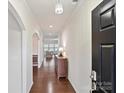 Inviting foyer featuring hardwood floors, white walls and decorative lighting with an archway leading to other rooms at 11621 Red Knoll Ln, Pineville, NC 28134