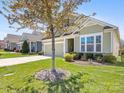 Well-maintained home with a two-car garage, lush lawn, and mature tree at 121 Hanks Bluff Dr, Mooresville, NC 28117
