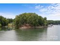Aerial view of the wooded home featuring outdoor patio area with lake access and waterfront views at 121 Rhinehill Dr, Mooresville, NC 28117