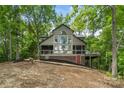 Lake house with a screened-in porch, deck, and large windows offering serene waterfront views at 121 Rhinehill Dr, Mooresville, NC 28117