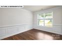 Bright living room with decorative molding, chair rail, and large window that allows ample natural light at 134 Asmodean Ln, Troutman, NC 28166