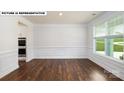 Bright living room with decorative molding, chair rail, and large window; features hardwood flooring at 134 Asmodean Ln, Troutman, NC 28166