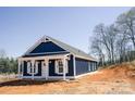 Quaint blue home featuring a welcoming front porch and a well-manicured, spacious yard at 1432 Blackbird Dr, Clover, SC 29710