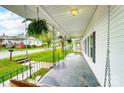 Inviting covered porch with hanging plants and wooden swing, perfect for relaxing outdoors at 26 Park Dr, Gastonia, NC 28054