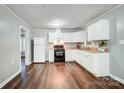 Bright kitchen with white cabinets, modern appliances, and hardwood floors at 26 Park Dr, Gastonia, NC 28054