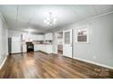 Open-concept kitchen with white cabinetry, adjacent dining area, and wood floors at 26 Park Dr, Gastonia, NC 28054