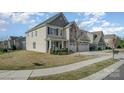 Well-maintained two-story home with a charming front porch and a three-car garage and manicured lawn at 276 Annatto Way, Tega Cay, SC 29708