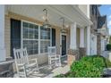 Charming front porch with rocking chairs and stylish lighting, inviting you to relax and enjoy the outdoors at 276 Annatto Way, Tega Cay, SC 29708