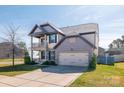 Charming two-story home with a covered porch, balcony, manicured lawn and attached two-car garage at 3124 Berry Creek Rd, Charlotte, NC 28214