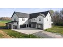 Stylish home featuring a contrasting black and white exterior, a spacious driveway, and a detached garage at 3907 E Lawyers Rd, Monroe, NC 28110
