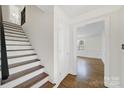 Inviting entryway featuring hardwood floors and staircase, creating a warm and welcoming ambiance at 4601 Crooked Oak Ln, Charlotte, NC 28226