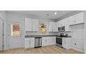 Bright kitchen featuring white cabinets, stainless steel appliances, and granite countertops at 607 S 10Th St, Bessemer City, NC 28016