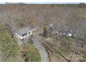 Aerial view showcasing home, detached garage with multiple cars, and a long winding driveway at 7218 Alexander Farm Rd, Monroe, NC 28110