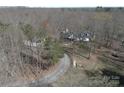 An aerial shot of a sprawling property featuring a white home with mature trees and a gravel driveway at 7218 Alexander Farm Rd, Monroe, NC 28110