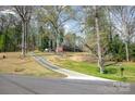 Brick home with a long driveway amid a scenic landscape of trees at 724 Rocky River W Rd, Charlotte, NC 28213