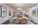 Bright dining area featuring hardwood floors, modern chandelier, and a seamless transition to the living room at 7865 Iron Rd, Sherrills Ford, NC 28673
